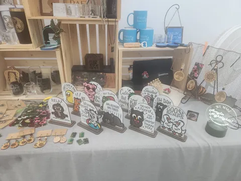Booth display of engraved wine glasses, tumblers, and handmade jewelry