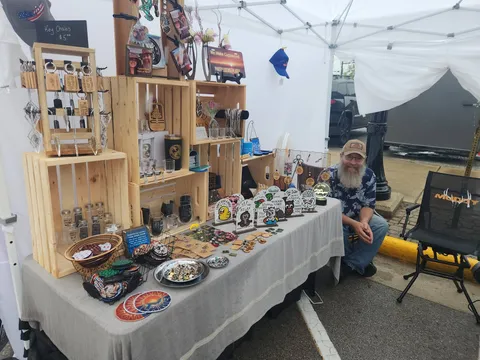 Booth display of engraved keychains, custom photo prints, and coasters